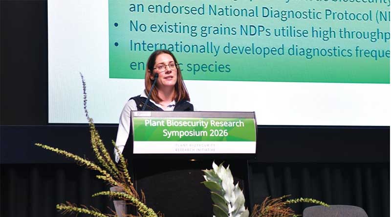 A speaker presenting research at a plant biosecurity symposium.